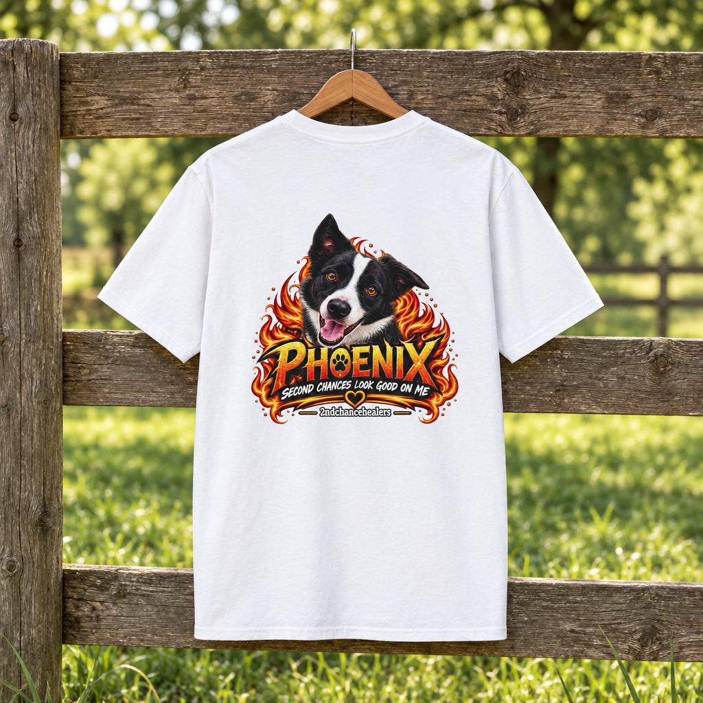A white short-sleeve t-shirt with a large graphic print on the front featuring a black and white dog's face surrounded by flames and the text 'PHOENIX' and 'BIRDS OF FEATHER LOOK GOOD ON ME'.